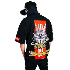 Puede incluir: Camiseta negra de manga corta con un gran diseño de cabeza de robot en la espalda, con una calavera y huesos cruzados. El diseño incluye detalles en rojo y amarillo, y el texto "DXPRO LINE". La camiseta tiene un corte holgado.