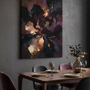 K&ouml;nnte beinhalten: Abstrakte Blumenleinwandkunst in Schwarz-, Lila- und Goldt&ouml;nen. Das Kunstwerk h&auml;ngt &uuml;ber einem Esstisch, der mit Tellern, Besteck und Weingl&auml;sern gedeckt ist. Der Raum hat dunkelgraue W&auml;nde und Samtst&uuml;hle.