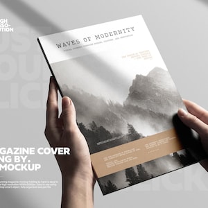 May include: A4 magazine cover mockup held by a hand. The cover features the text "WAVES OF MODERNITY" above a grayscale mountain landscape image. The magazine has a tan-colored band across the bottom with text. The words "JUST DOUBLE CLICK" are in the background.