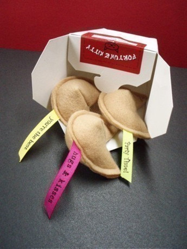 May include: Four fortune cookie-shaped plush toys with different messages on the attached ribbons. The messages are "You're the best", "Hugs & Kisses", "Party Time!" and "Good Times!"