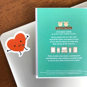 May include: Sticker card with a red heart with a smiling face and two small legs. The card has a teal background and text that reads "Sticker Card by Night Owl Paper Goods". The text continues, "You're special and so is this card. Peel off the sticker and apply it to one of your favorite devices to make your daily doings all the more fun. Thick, durable vinyl sticker is weatherproof and dishwasher safe making it versatile enough to use on cars, bikes and all sorts of gear! Printed & Hand Assembled in the USA - Birmingham, Alabama. Eco-friendly FSC Certified Paper Made with Zero Emission Wind Generated Power. For additional gifts & goodies visit NightOwlPaperGoods.com"