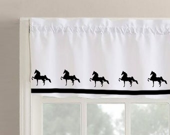 Puede incluir: Valance blanca con borde negro y un patrón repetido de siluetas de caballos negros.