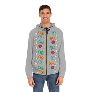 Pode incluir: Um moletom cinza com zíper que tem um design de fita de DNA estampado na frente. A fita de DNA é composta por hexágonos coloridos com as letras A, T, C e G impressas neles.