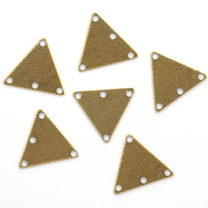 May include: Six antique gold triangle charms with three holes each. The charms have a textured surface and are perfect for jewelry making.