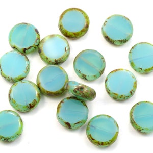 May include: A collection of 14 round, turquoise glass beads with a green and brown mottled pattern. The beads are approximately 1 inch in diameter.
