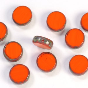 May include: Ten round orange glass beads with a mottled green and white pattern on the edges.