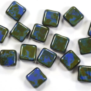 May include: A group of 15 square glass beads with a blue and green marbled pattern.