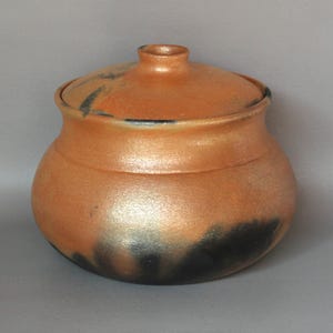 May include: A white ceramic mug with a black handle and the text "But First, Coffee" in a handwritten style. The mug is on a white surface. The mug is 4 inches tall.