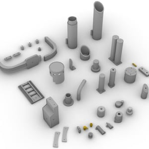Puede incluir: Un surtido de piezas grises impresas en 3D, que incluyen cilindros, tubos y piezas rectangulares, se disponen sobre una superficie blanca. Algunas piezas tienen pequeños detalles dorados. La colección parece ser componentes para un ensamblaje más grande.