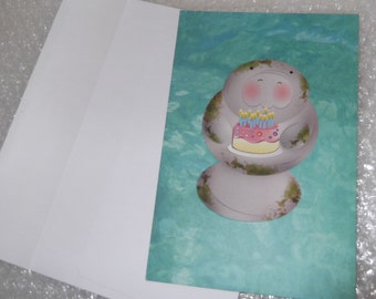 Manatee with blushing cheeks holding birthday cake Happy Birthday greeting card