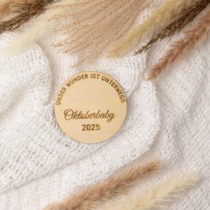 Holzscheibe Unser Wunder ist unterwegs Oktoberbaby 2025 10cm Durchmesser, Verkündung Schwangerschaft Oktober 2025 Meilensteinkarte