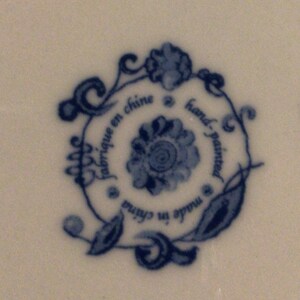 May include: Blue and white floral design with the text "fabrique en chine" and "hand-painted" in a circle.