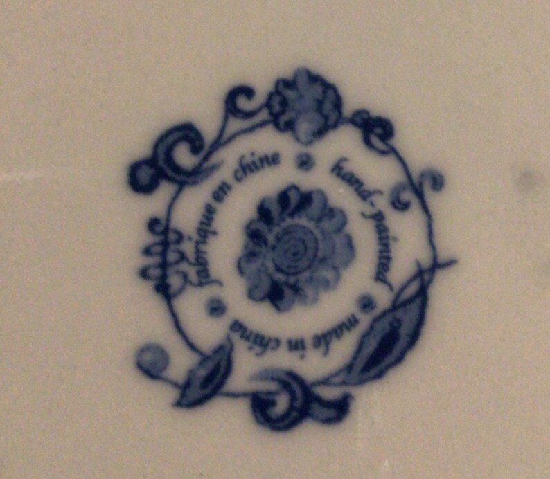 May include: Blue and white floral design with the text "fabrique en chine" and "hand-painted" in a circle.