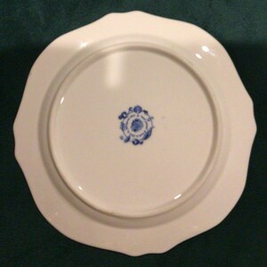 May include: White ceramic plate with a scalloped edge and a blue and white floral design on the bottom.