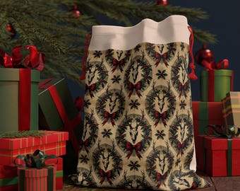 May include: A beige Christmas gift bag featuring a repeating pattern of deer skulls, wreaths, and red bows. The bag has a white top and red drawstring. Presents and a Christmas tree are in the background.