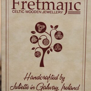 May include: A brown paper card with the text "Fretmajic Celtic Wooden Jewellery" and a stylized tree with Celtic knots. The text "Handcrafted by Juliette in Galway, Ireland" is also on the card.
