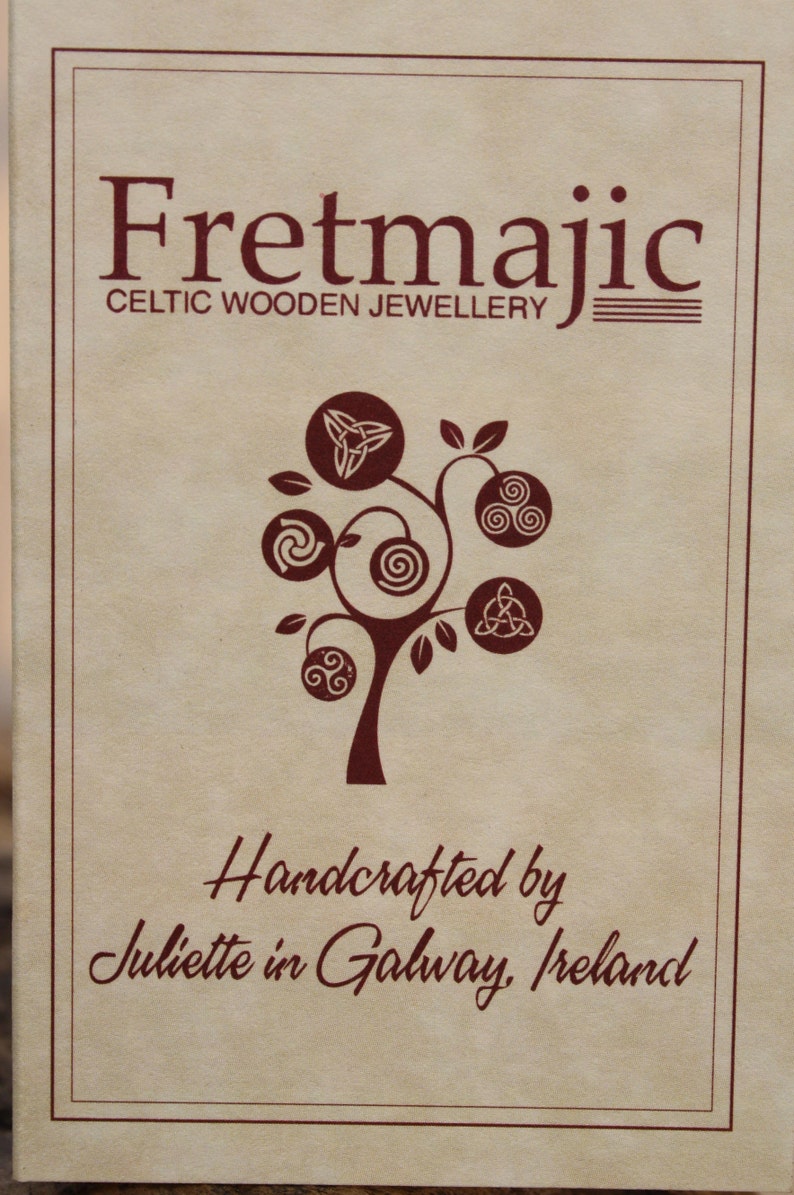 May include: A brown paper card with the text "Fretmajic Celtic Wooden Jewellery" and a stylized tree with Celtic knots. The text "Handcrafted by Juliette in Galway, Ireland" is also on the card.