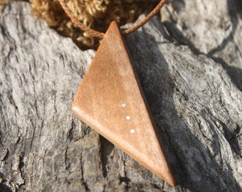 May include: A wooden triangle pendant necklace with a brown cord. The pendant has three small silver dots on it.