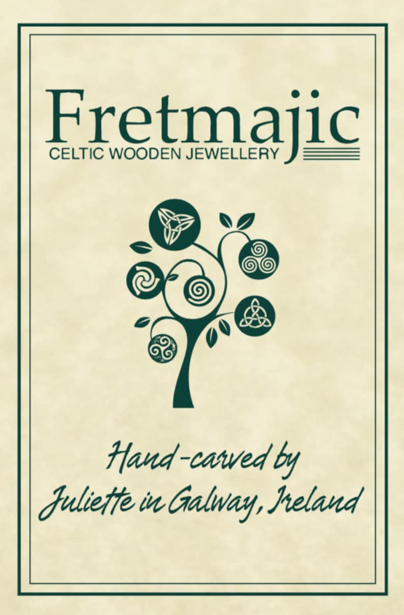 May include: A logo for Fretmajic Celtic Wooden Jewellery, featuring a stylized tree with Celtic knot designs on each branch. The text "Hand-carved by Juliette in Galway, Ireland" is below the tree.