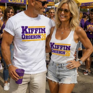 May include: A white short-sleeved t-shirt and a white sleeveless tank top, both featuring the purple and gold text "KIFFIN ORGERON 26" printed on the front. The garments are made of a lightweight fabric and display a bold, athletic-style font.