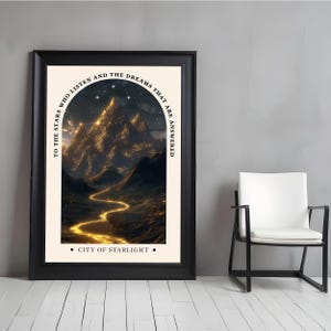 Puede incluir: Impresi&oacute;n art&iacute;stica enmarcada que presenta un paisaje monta&ntilde;oso iluminado con luz dorada, con el texto "TO THE STARS WHO LISTEN AND THE DREAMS THAT ARE ANSWERED" y "CITY OF STARLIGHT." La obra est&aacute; en un marco negro.