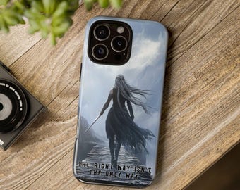May include: A phone case featuring a dramatic illustration of a figure with long hair holding a sword, set against a mountainous backdrop. The case has the text "THE RIGHT WAY ISN'T THE ONLY WAY" at the bottom. The case is on a wooden surface.