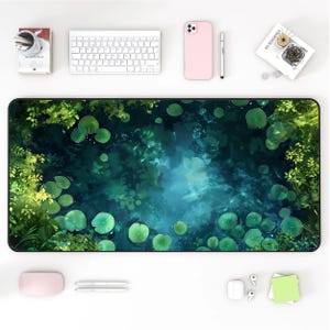 May include: A rectangular desk mat with a tranquil pond design, showing lily pads and verdant foliage in green and blue hues. Office items, such as a keyboard, phone, and pens, surround the mat.