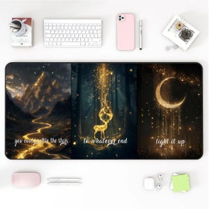 May include: A black rectangular desk mat featuring three artistic panels with gold accents. The panels depict a mountain landscape, a deer in a forest, and a crescent moon. Text includes "you could rattle the stars", "to whatever end", and "light it up".