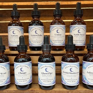 May include: Ten small brown glass bottles with droppers, each containing a different herbal extract. The bottles are labeled with the name of the herb, "Willow Moon Herbals", and a crescent moon logo. The herbs include Yarrow, Lemon Balm, Usnea, Nettle Seed, St. Johns Wort, Chaga, Ghost Pipe, Reishi Mushroom, and Ashwagandha.