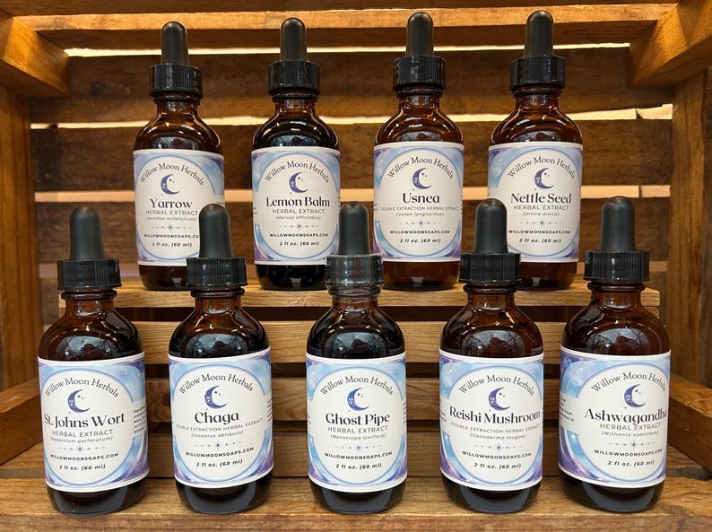 May include: Ten small brown glass bottles with droppers, each containing a different herbal extract. The bottles are labeled with the name of the herb, "Willow Moon Herbals", and a crescent moon logo. The herbs include Yarrow, Lemon Balm, Usnea, Nettle Seed, St. Johns Wort, Chaga, Ghost Pipe, Reishi Mushroom, and Ashwagandha.