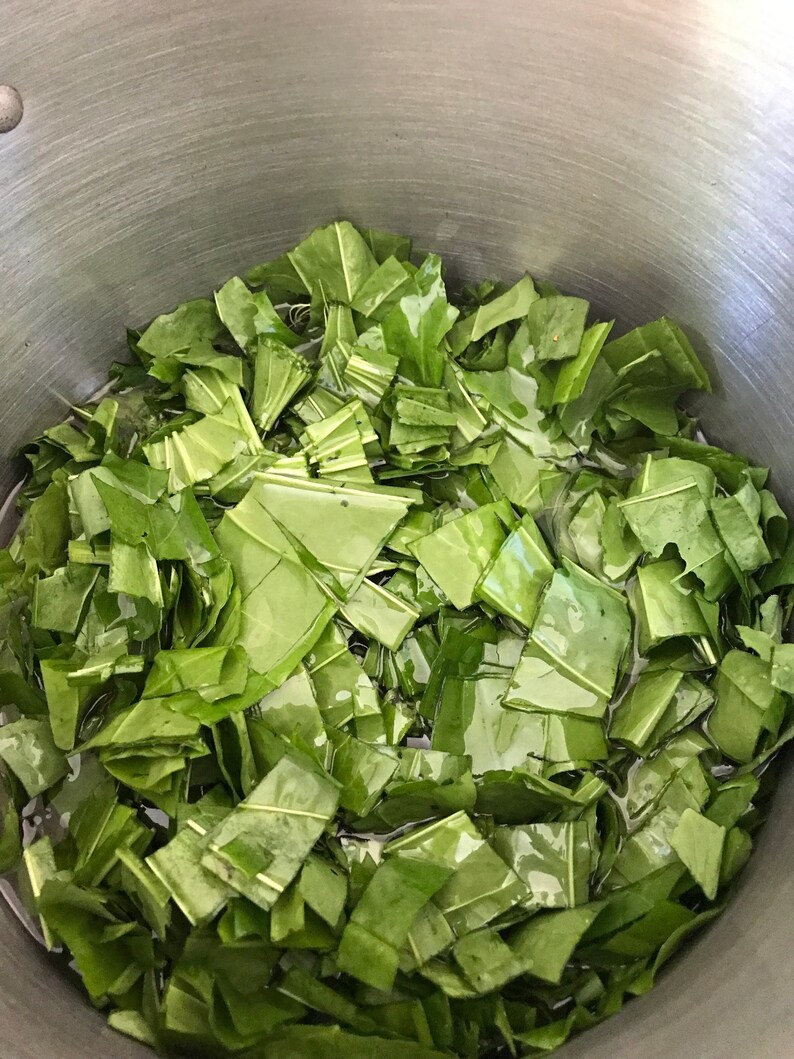 以下が含まれることがあります： 刻んだ緑の葉野菜でいっぱいになった大きなステンレス製の鍋