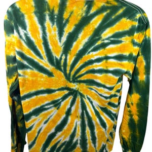 May include: Long-sleeved shirt with a green and yellow tie-dye pattern. The shirt has a crew neck and long sleeves.