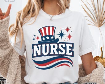 Puede incluir: Camiseta blanca con un diseño patriótico. Presenta un sombrero de copa, estrellas y la palabra "NURSE" en letras gruesas. El diseño utiliza los colores rojo, blanco y azul, creando un tema patriótico.