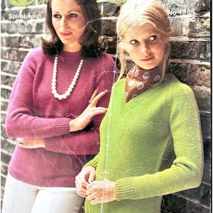Puede incluir: Dos mujeres con suéteres de punto posan frente a una pared de ladrillos. Una mujer lleva un suéter magenta de cuello redondo y un collar de perlas. La otra lleva un suéter verde lima con cuello en V y una bufanda estampada. La imagen tiene el texto "Spiral-spun" y "No 4384".