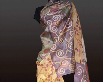 May include: A long, flowing silk scarf with a hand-painted design featuring swirling patterns in shades of purple, yellow, and green. The scarf is draped over a mannequin.