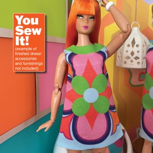 Puede incluir: Una muñeca con un vestido sin mangas con un gran diseño de flores en tonos rosa, verde, azul y naranja. El vestido tiene un patrón geométrico. La muñeca tiene el pelo naranja y lleva una diadema blanca. El texto "You Sew It!" es visible en la imagen.