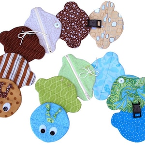 May include: A colorful caterpillar made of fabric with different patterns and colors. Each segment of the caterpillar has a zipper closure and some have buttons. The caterpillar is made of brown, green, blue, and white fabric.
