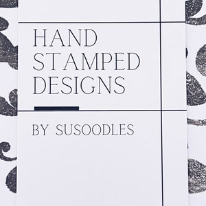 May include: A white card with black text that reads "HAND STAMPED DESIGNS BY SUSOODLES" and a website address: www.susoodles.etsy.com