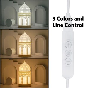 May include: White decorative lamp shaped like a mosque with three different colored light settings. The lamp is controlled by a white cord with a button to change the color of the light.