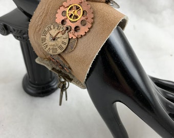 Steampunk elements leather bracelet.  Many gears attached to leather then attached to 2” wide leather base.