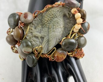 Cuff bracelet wire wrangling and carved eagle stone and smaller natural stones.