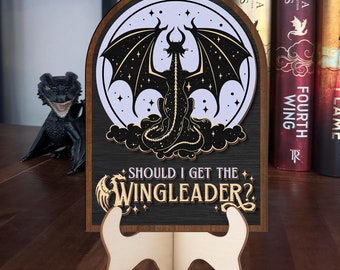 May include: A wooden sign with a black dragon silhouette on a white moon background. The sign reads "Should I get the Wingleader?" and is on a small wooden stand.