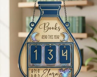 May include: A wooden book counter in a potion bottle shape, with the text "Books READ THIS YEAR" and the name "Elara". The counter has blue and beige accents, with a chain for hanging. The counter shows the number 134.