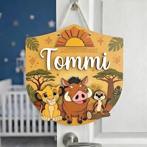 Puede incluir: Letrero de madera con personajes de El Rey León, incluyendo a Simba, Pumbaa y Timón. El letrero es amarillo con el nombre "Tommi" en escritura blanca. El diseño incluye un sol, árboles y patrones decorativos, colgado de una cuerda blanca.