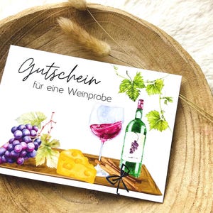 Könnte beinhalten: Ein weißer Geschenkgutschein mit dem Text "Gutschein für eine Weinprobe". Der Gutschein zeigt eine Aquarell-Illustration einer Weinflasche, einem Glas Rotwein, Trauben, Käse und Zimtstangen.