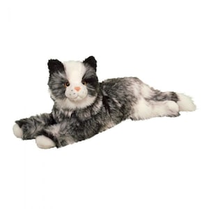 May include: A plush cat toy in a reclining pose. The cat has a white face and chest, with black ears and gray and white fur on its body. The toy has orange eyes and a pink nose.
