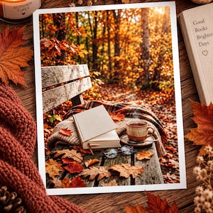 Op de afbeelding: Een rechthoekige fotoprint met een parkbank in een herfstbos met een boek, een dampende mok en een bril op een geruite deken. De scène is omgeven door gevallen oranje bladeren, een kaars, een pompoen en een boek met de titel Good Books Brighter Days.