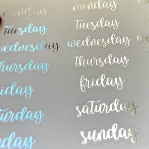 May include: A sheet of clear stickers with silver foil lettering for each day of the week. The stickers are designed for use in planners and journals.