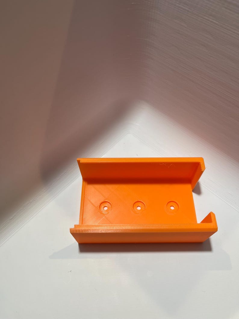 May include: Orange 3D printed plastic case with three holes.