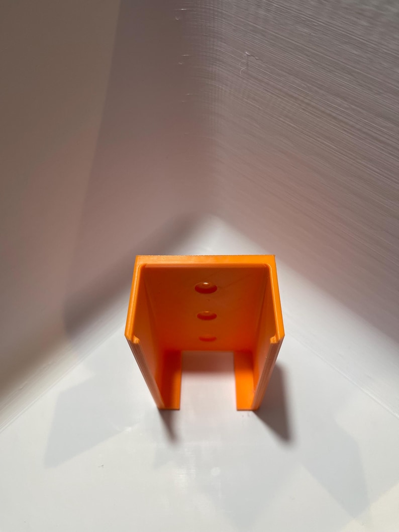 May include: Orange plastic wall mount with three holes.